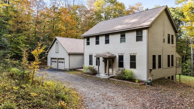 colonial house with an outdoor structure and a garage