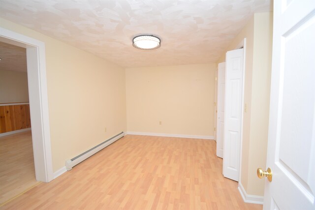 empty room featuring light hardwood / wood-style flooring and a baseboard radiator