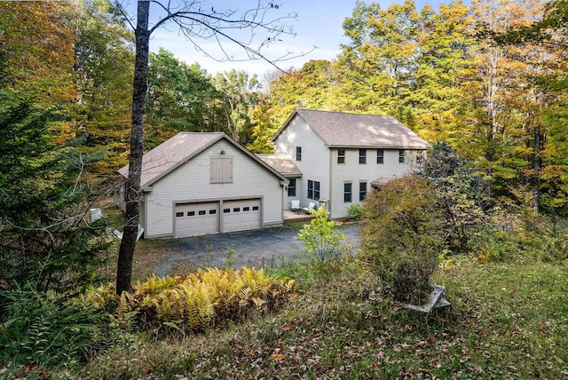 view of front of house featuring a garage and an outbuilding