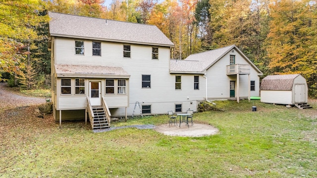 rear view of property with a yard and a storage shed