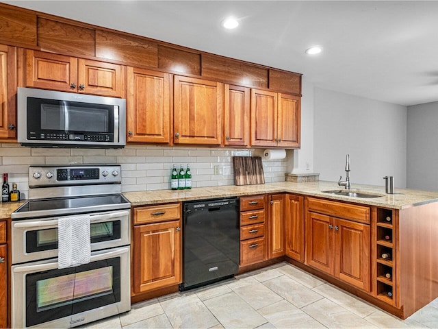 kitchen featuring appliances with stainless steel finishes, light stone countertops, sink, and backsplash