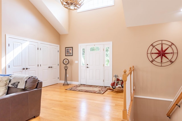 foyer entrance with an inviting chandelier, hardwood / wood-style floors, and a high ceiling