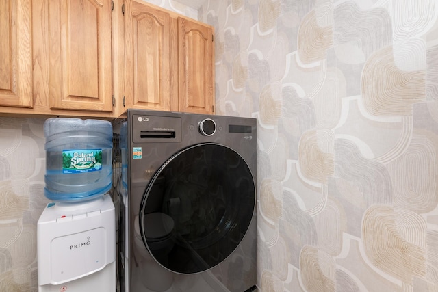 laundry area featuring washer / clothes dryer and cabinets