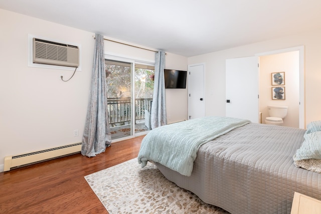 bedroom with a wall unit AC, hardwood / wood-style floors, a baseboard radiator, access to exterior, and ensuite bath