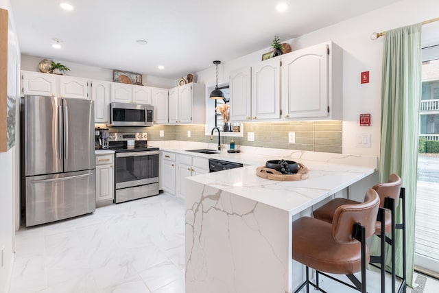 kitchen featuring white cabinetry, appliances with stainless steel finishes, and plenty of natural light