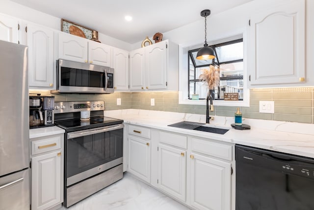 kitchen featuring appliances with stainless steel finishes, white cabinetry, sink, and backsplash