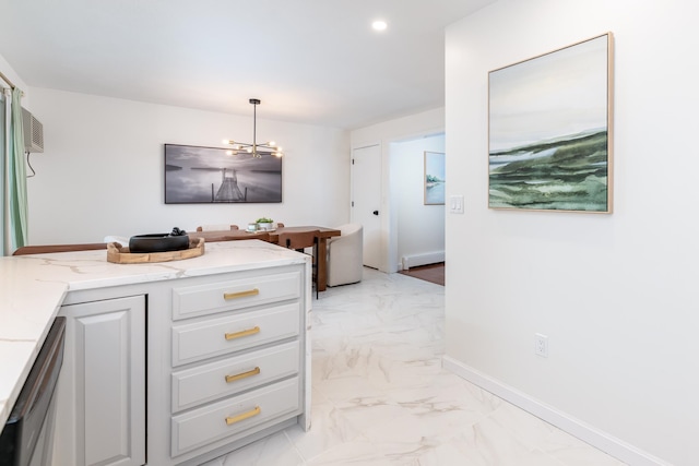 interior space featuring light stone countertops, dishwasher, baseboard heating, pendant lighting, and a notable chandelier