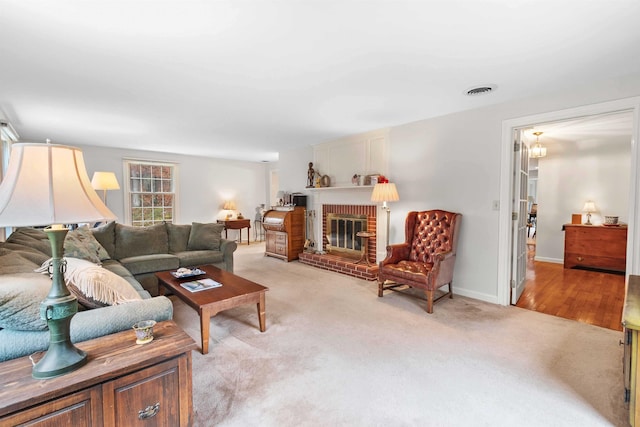 living room with light colored carpet and a brick fireplace