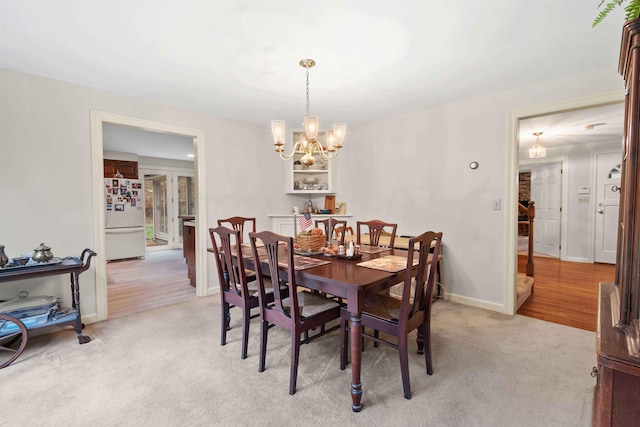 carpeted dining room with an inviting chandelier