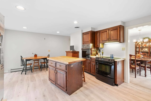 kitchen featuring a kitchen island, stainless steel oven, baseboard heating, black range with electric cooktop, and light hardwood / wood-style floors