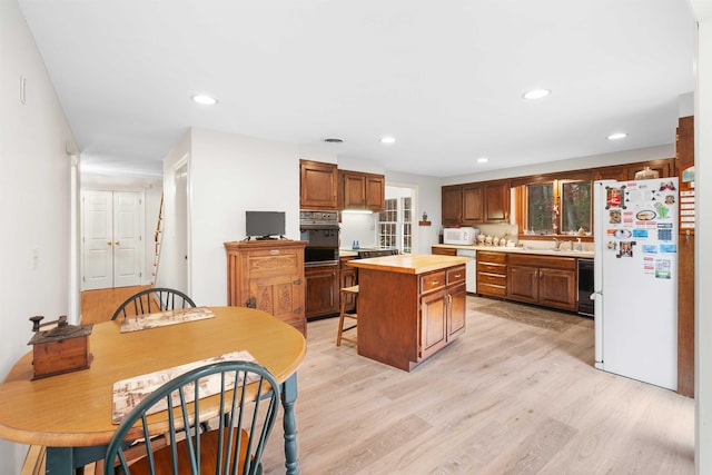 kitchen featuring light hardwood / wood-style flooring, black appliances, sink, and a kitchen island