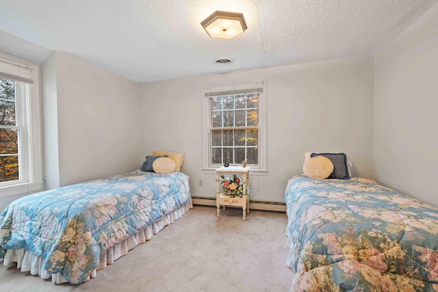 carpeted bedroom featuring a textured ceiling and a baseboard radiator