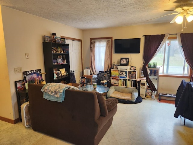 living room with a textured ceiling and ceiling fan