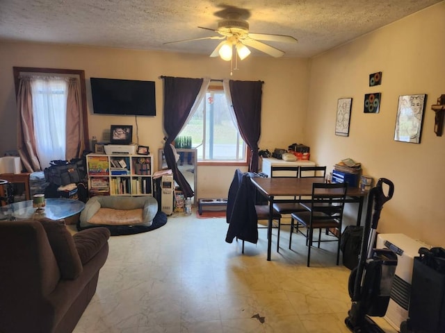 dining room featuring ceiling fan and a textured ceiling