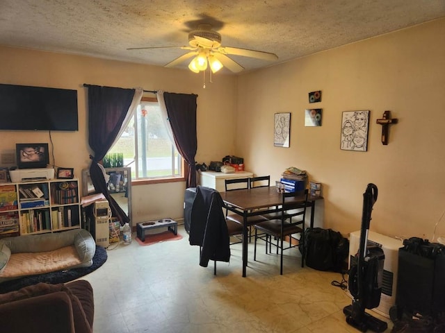 dining area featuring ceiling fan and a textured ceiling