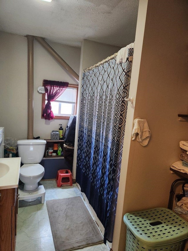 bathroom featuring curtained shower, vanity, a textured ceiling, and toilet