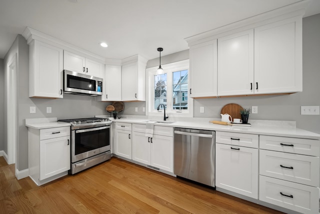 kitchen featuring appliances with stainless steel finishes, light wood-type flooring, and white cabinets