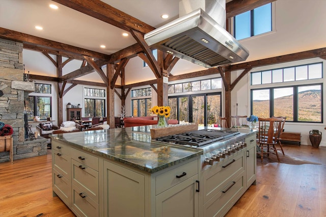 kitchen featuring light hardwood / wood-style floors, beamed ceiling, island range hood, and a wealth of natural light