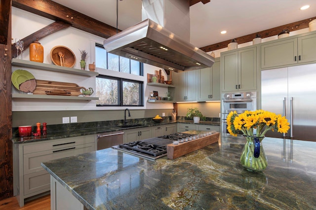 kitchen featuring appliances with stainless steel finishes, sink, island range hood, dark stone countertops, and beam ceiling