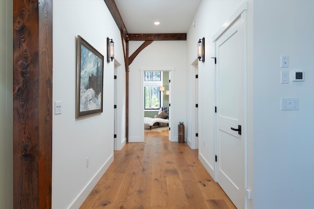 hallway with beamed ceiling and light wood-type flooring