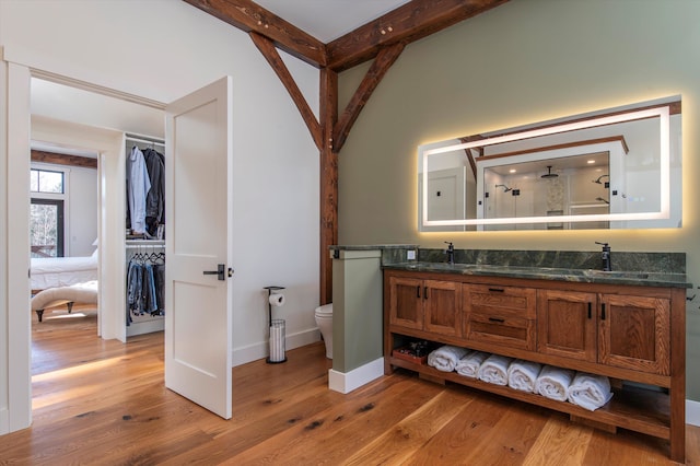 bathroom with vanity, a shower, hardwood / wood-style flooring, and toilet