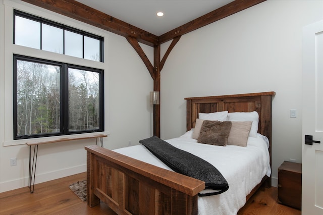 bedroom featuring beamed ceiling and hardwood / wood-style floors