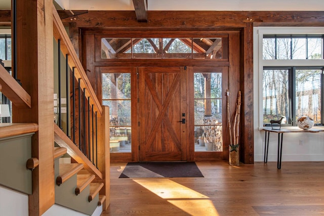 foyer entrance featuring beamed ceiling and dark wood-type flooring