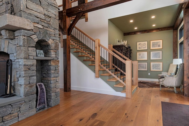 stairway with a fireplace and hardwood / wood-style flooring