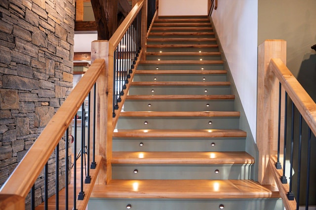 stairway featuring a towering ceiling