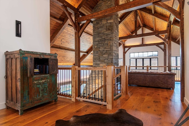 hallway featuring beamed ceiling, high vaulted ceiling, and wood-type flooring