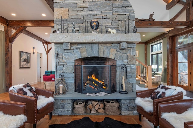 living room featuring beam ceiling, hardwood / wood-style flooring, and a fireplace