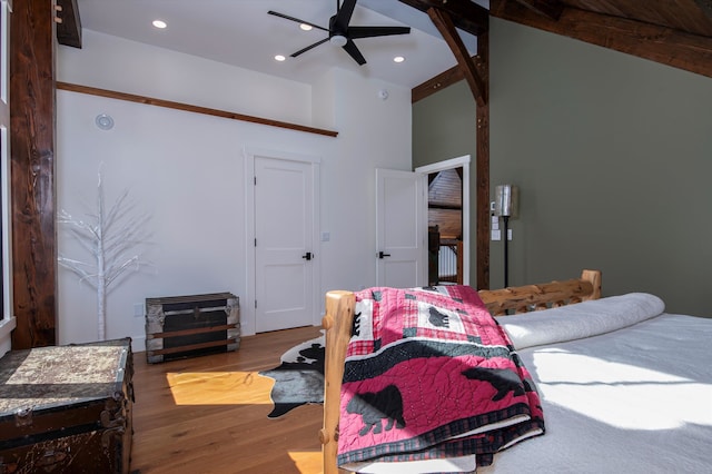 bedroom featuring beamed ceiling, wood-type flooring, high vaulted ceiling, and ceiling fan