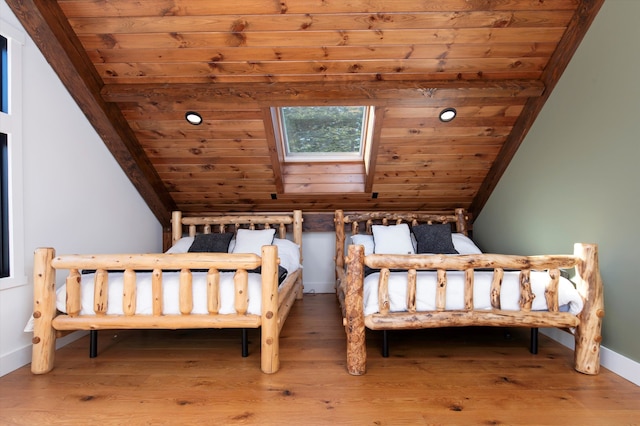 unfurnished bedroom with lofted ceiling with skylight, wood ceiling, and hardwood / wood-style flooring