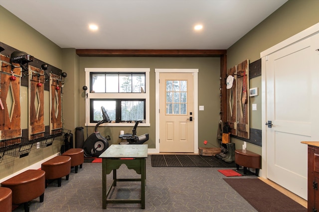 foyer featuring dark colored carpet