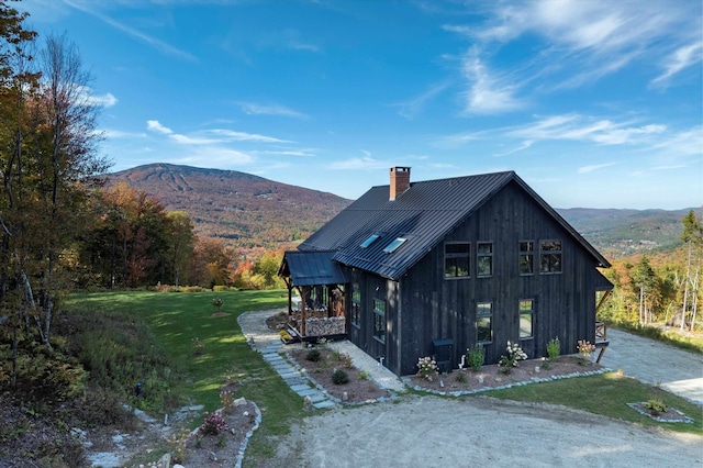 view of home's exterior featuring a mountain view and a lawn