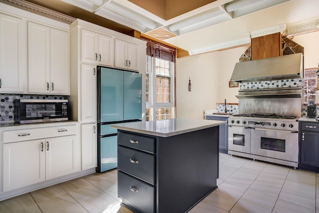 kitchen with a kitchen island, range with two ovens, backsplash, refrigerator, and white cabinetry