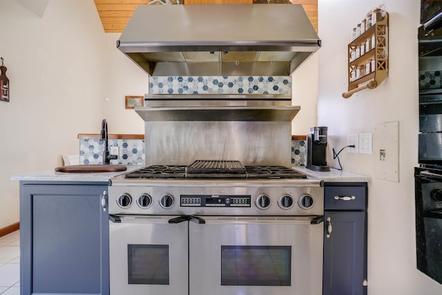 kitchen featuring stainless steel range, wall chimney exhaust hood, tasteful backsplash, and light tile patterned floors