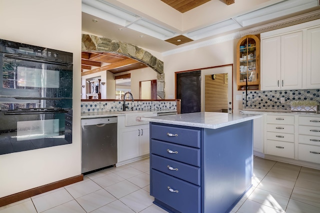 kitchen featuring a center island, stainless steel dishwasher, white cabinetry, black double oven, and tasteful backsplash