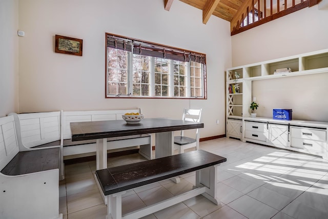 dining space featuring wood ceiling, high vaulted ceiling, breakfast area, light tile patterned flooring, and beamed ceiling