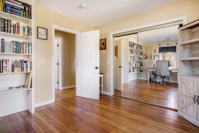 home office with hardwood / wood-style floors and a textured ceiling