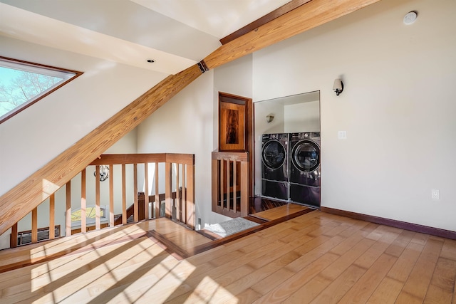 interior space featuring beam ceiling, separate washer and dryer, and hardwood / wood-style floors