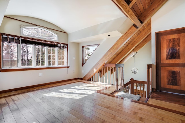 bonus room featuring dark hardwood / wood-style floors, high vaulted ceiling, and plenty of natural light