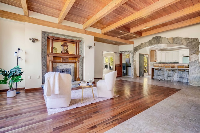 living room with beam ceiling, wood ceiling, and light hardwood / wood-style floors