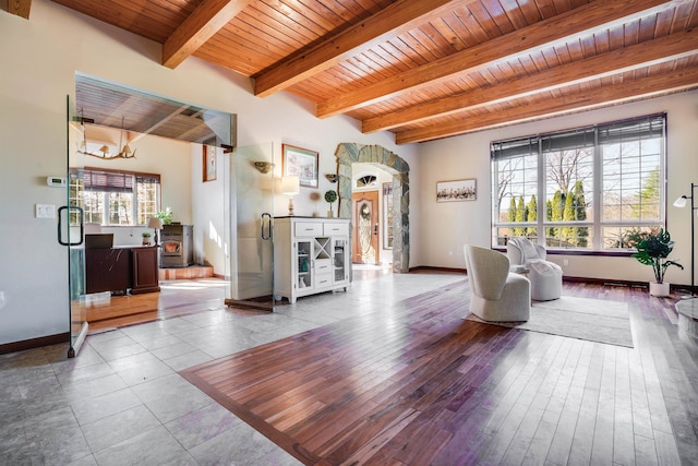 living room featuring beamed ceiling, tile patterned floors, wood ceiling, and an inviting chandelier