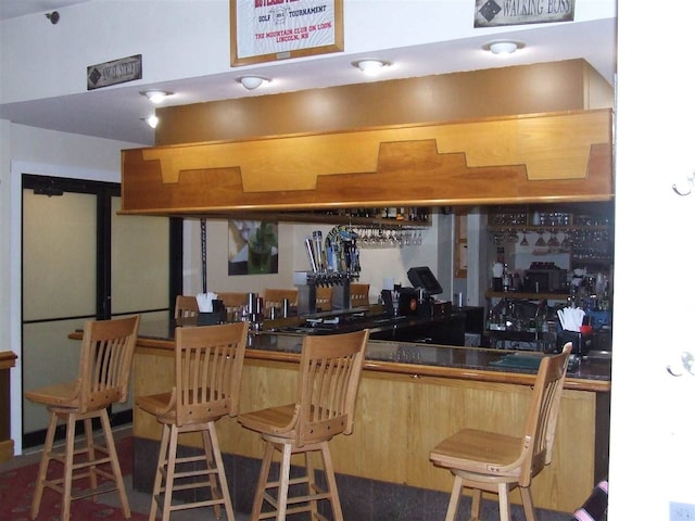 kitchen with a breakfast bar area and light brown cabinetry