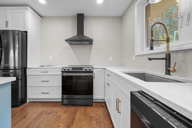 155 E Shore Dr, Weare, NH 03281 - kitchen featuring appliances with stainless steel finishes, wall chimney exhaust hood, a sink, recessed lighting, and light countertops