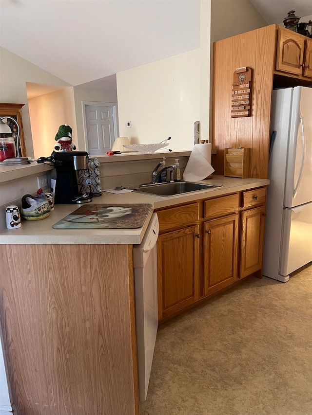 kitchen featuring lofted ceiling, sink, light colored carpet, and white appliances