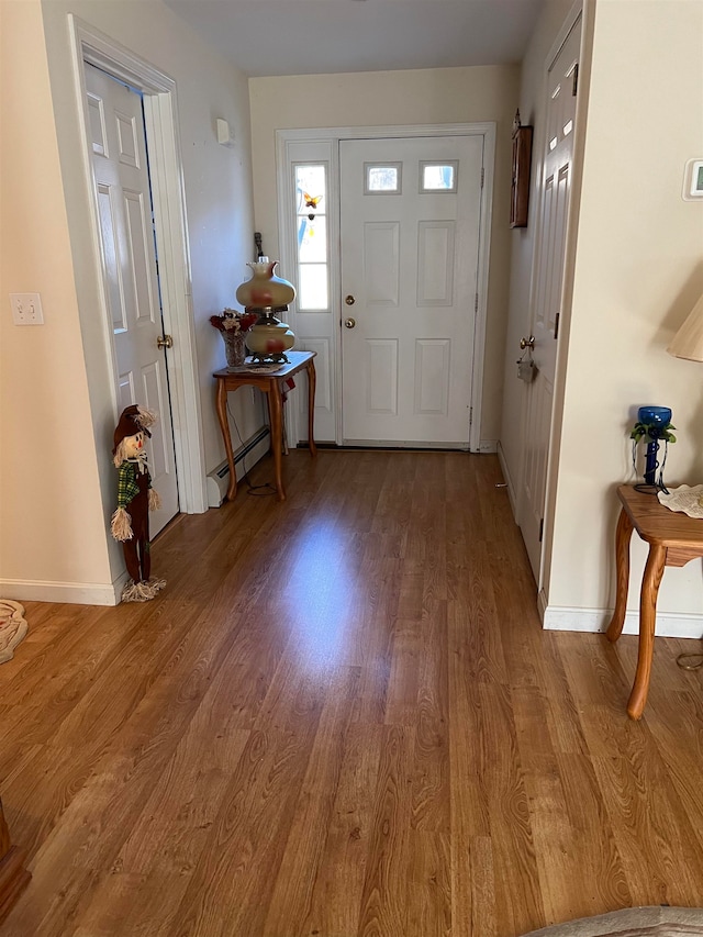 foyer with wood-type flooring and baseboard heating