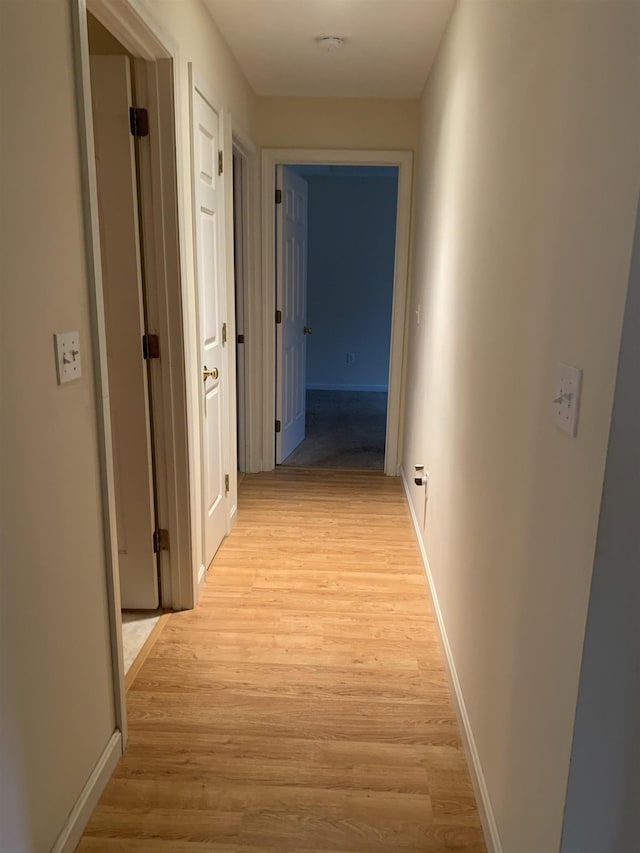 corridor with light hardwood / wood-style floors