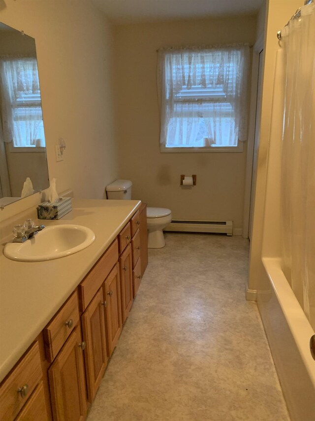 bathroom featuring toilet, vanity, and a baseboard heating unit